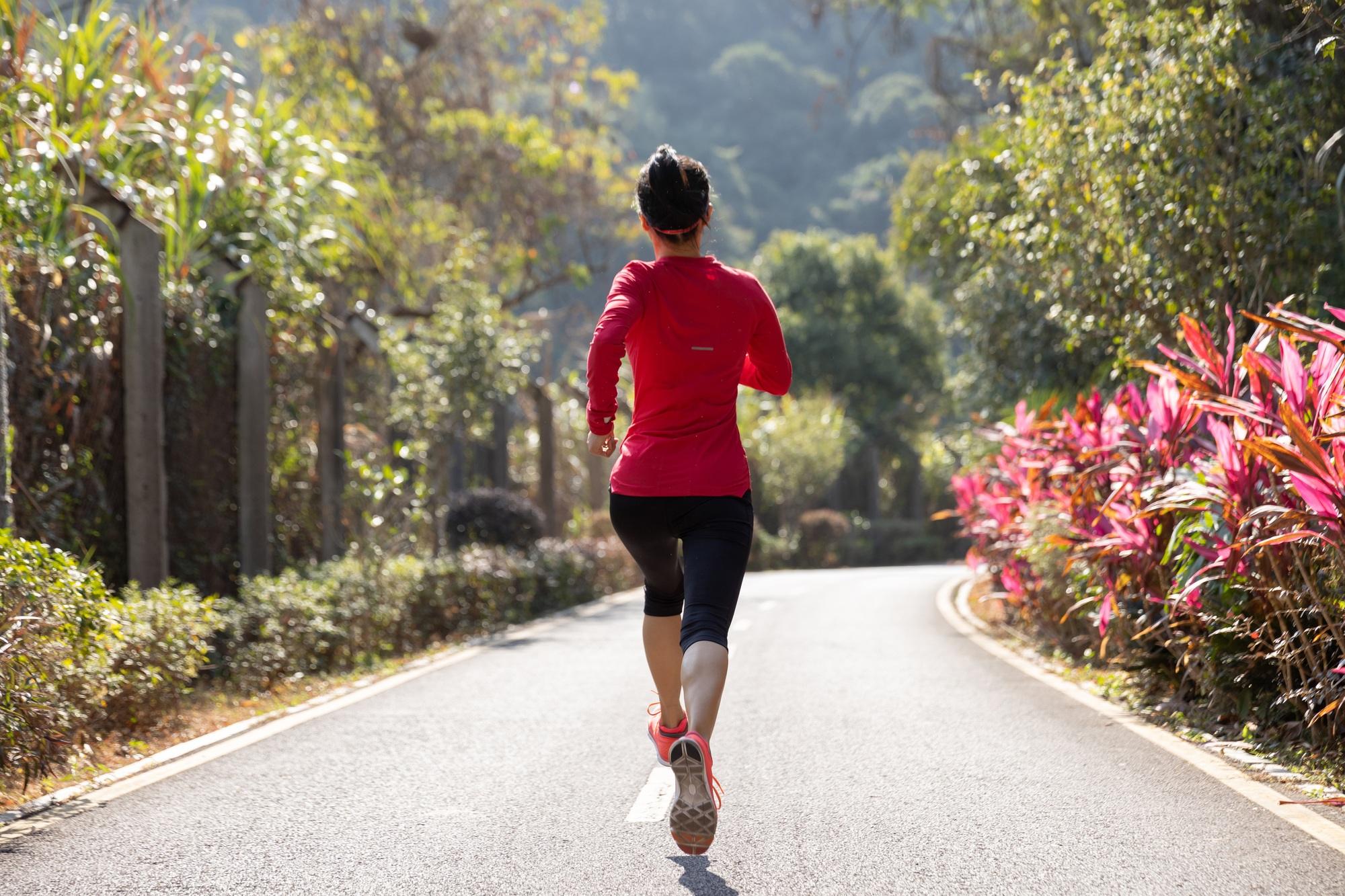 Fitness woman runner running on winter park trail